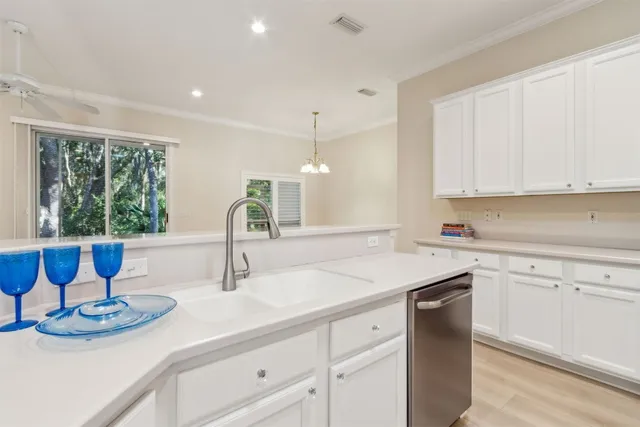 a kitchen with a refrigerator sink and white cabinets