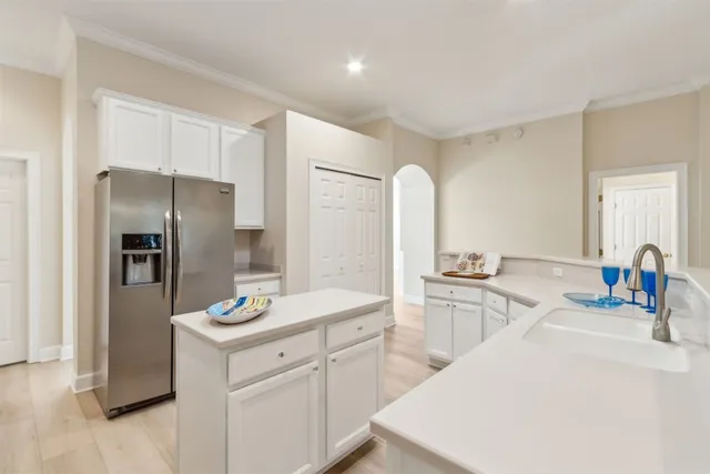 a kitchen with white cabinets and stainless steel appliances