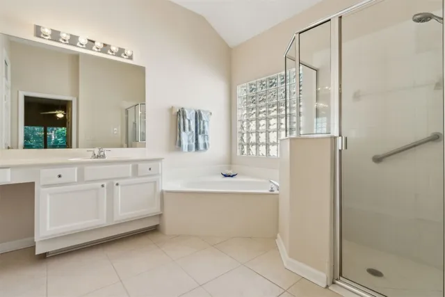 a view of a hallway with wooden floor and a bathroom