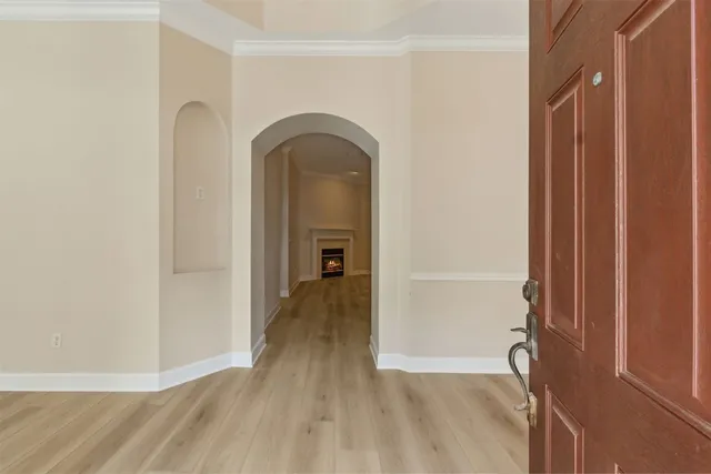 a view of a livingroom with wooden floor and a bathroom