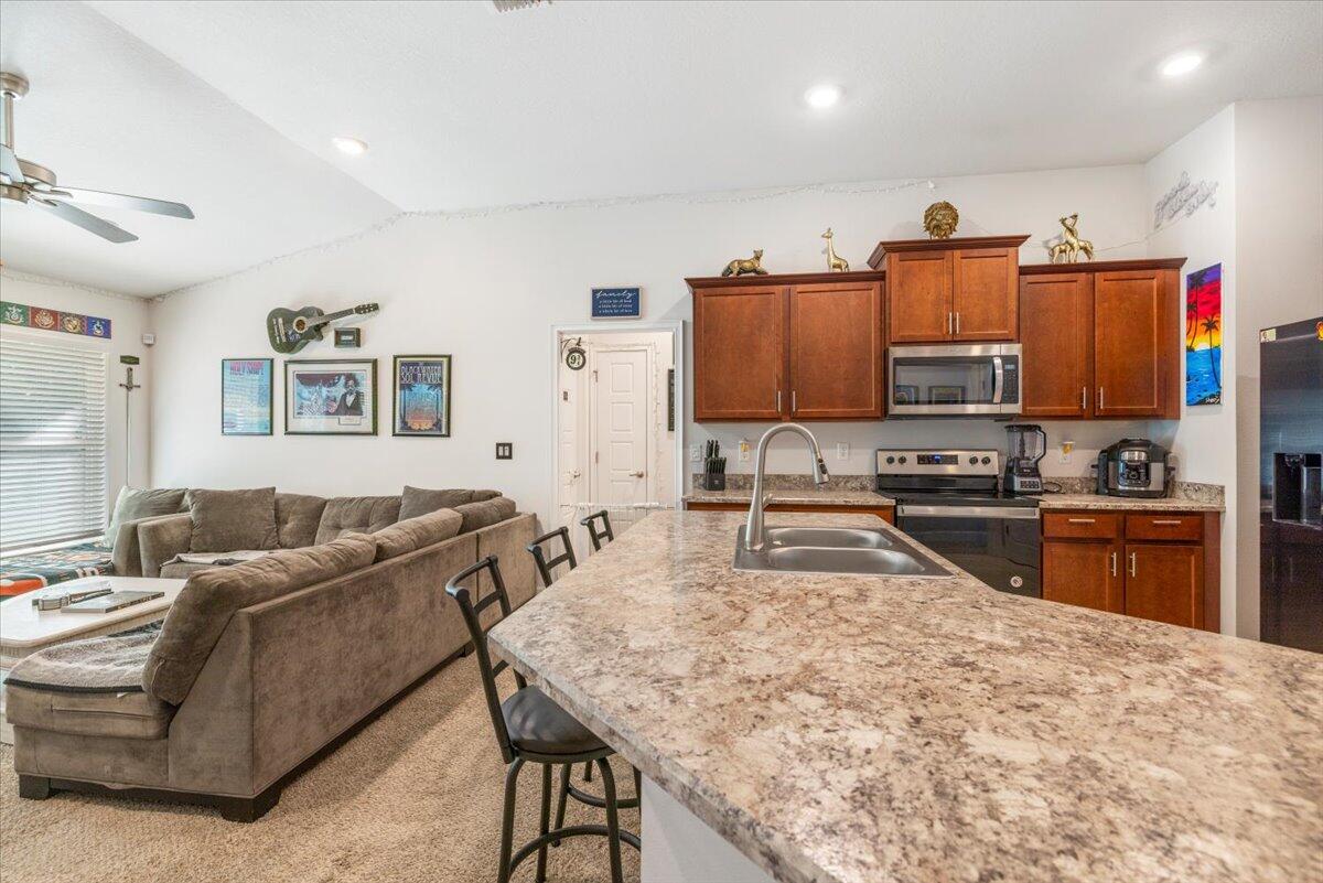 5348 Vespera Street Fort Pierce, FL 34951 - Photo 13 of 39 a living room with stainless steel appliances furniture a rug and a kitchen view