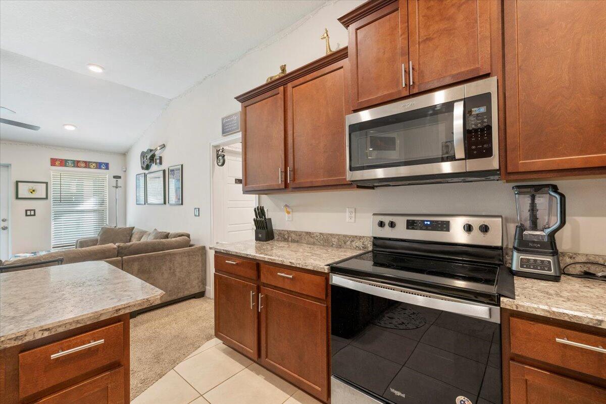 5348 Vespera Street Fort Pierce, FL 34951 - Photo 16 of 39 a kitchen with stainless steel appliances granite countertop a stove microwave and cabinets