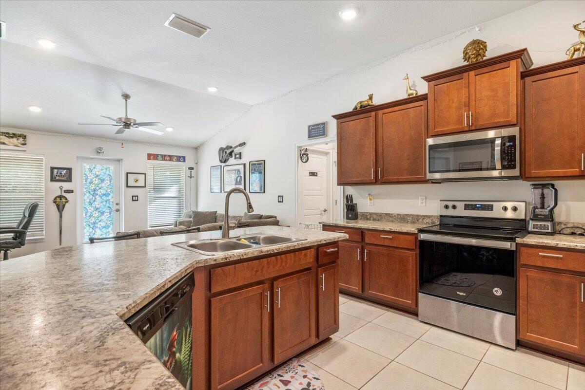 5348 Vespera Street Fort Pierce, FL 34951 - Photo 19 of 39 a kitchen with stainless steel appliances granite countertop a sink and stove top oven