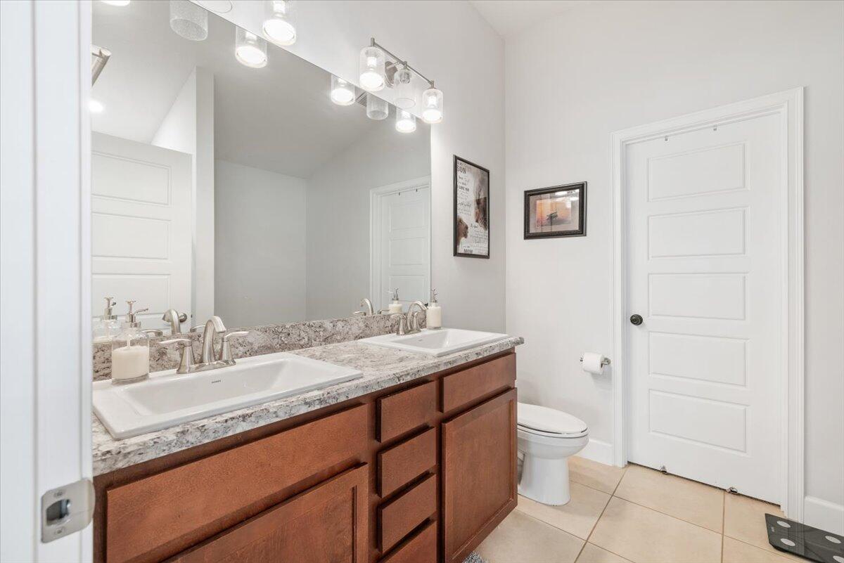 5348 Vespera Street Fort Pierce, FL 34951 - Photo 22 of 39 a bathroom with a granite countertop sink a toilet and a mirror