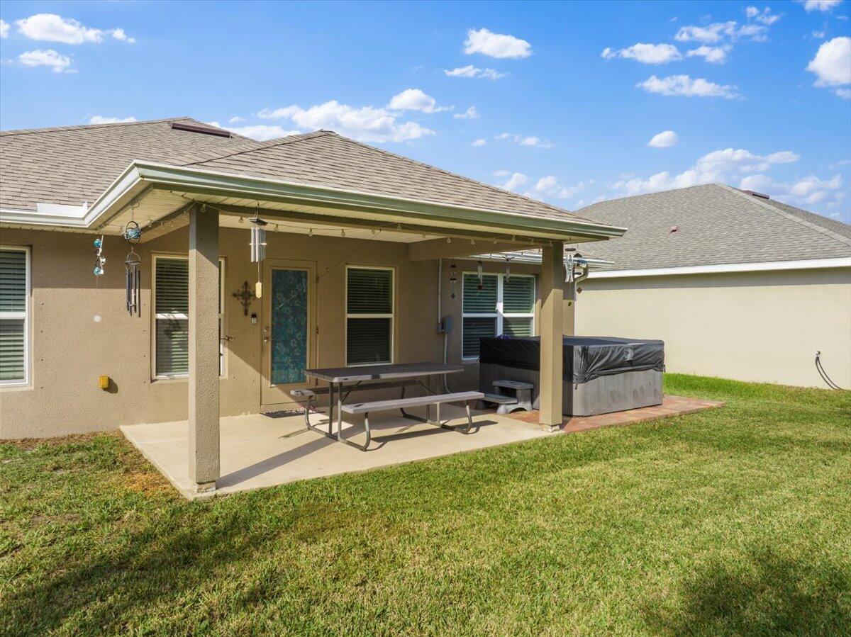 5348 Vespera Street Fort Pierce, FL 34951 - Photo 30 of 39 a view of a patio with table and chairs a barbeque with wooden fence