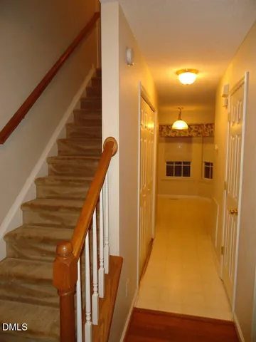 a view of a hallway with wooden floor and staircase