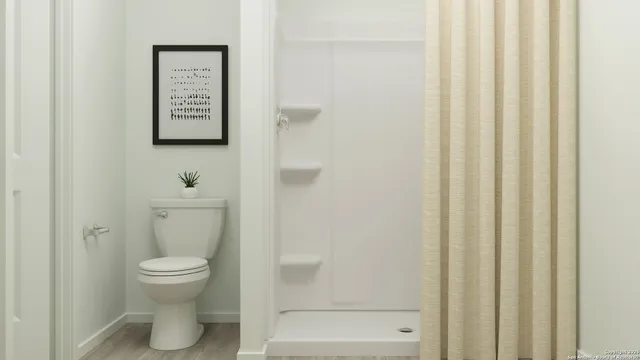 a bathroom with a toilet and a shower
