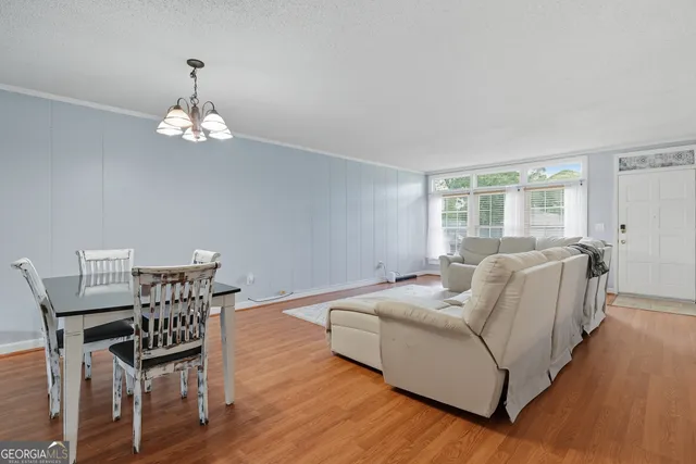 a living room with furniture chandelier and a window