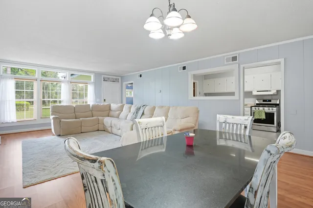 a living room with furniture dining table and a large window