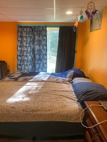 a bedroom with a bed and a window