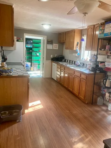 a kitchen with granite countertop a stove a sink and a wooden cabinets