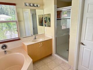 6075 Adriatic Way Greenacres, FL 33413 - Photo 14 of 24 a bathroom with a tub sink and mirror