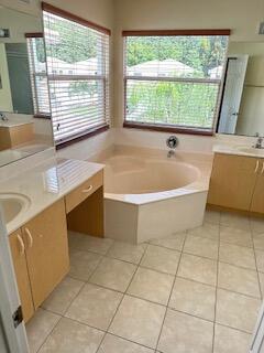 6075 Adriatic Way Greenacres, FL 33413 - Photo 15 of 24 a bath tub sitting in a bathroom next to a window