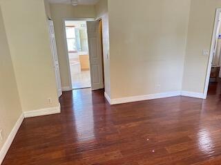 6075 Adriatic Way Greenacres, FL 33413 - Photo 17 of 24 a view of an empty room with wooden floor and a window