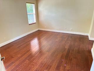 6075 Adriatic Way Greenacres, FL 33413 - Photo 19 of 24 an empty room with wooden floor and windows