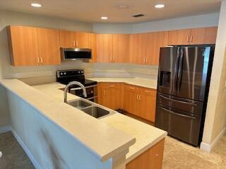 6075 Adriatic Way Greenacres, FL 33413 - Photo 9 of 24 a kitchen with stainless steel appliances granite countertop a refrigerator a sink a stove a microwave and island