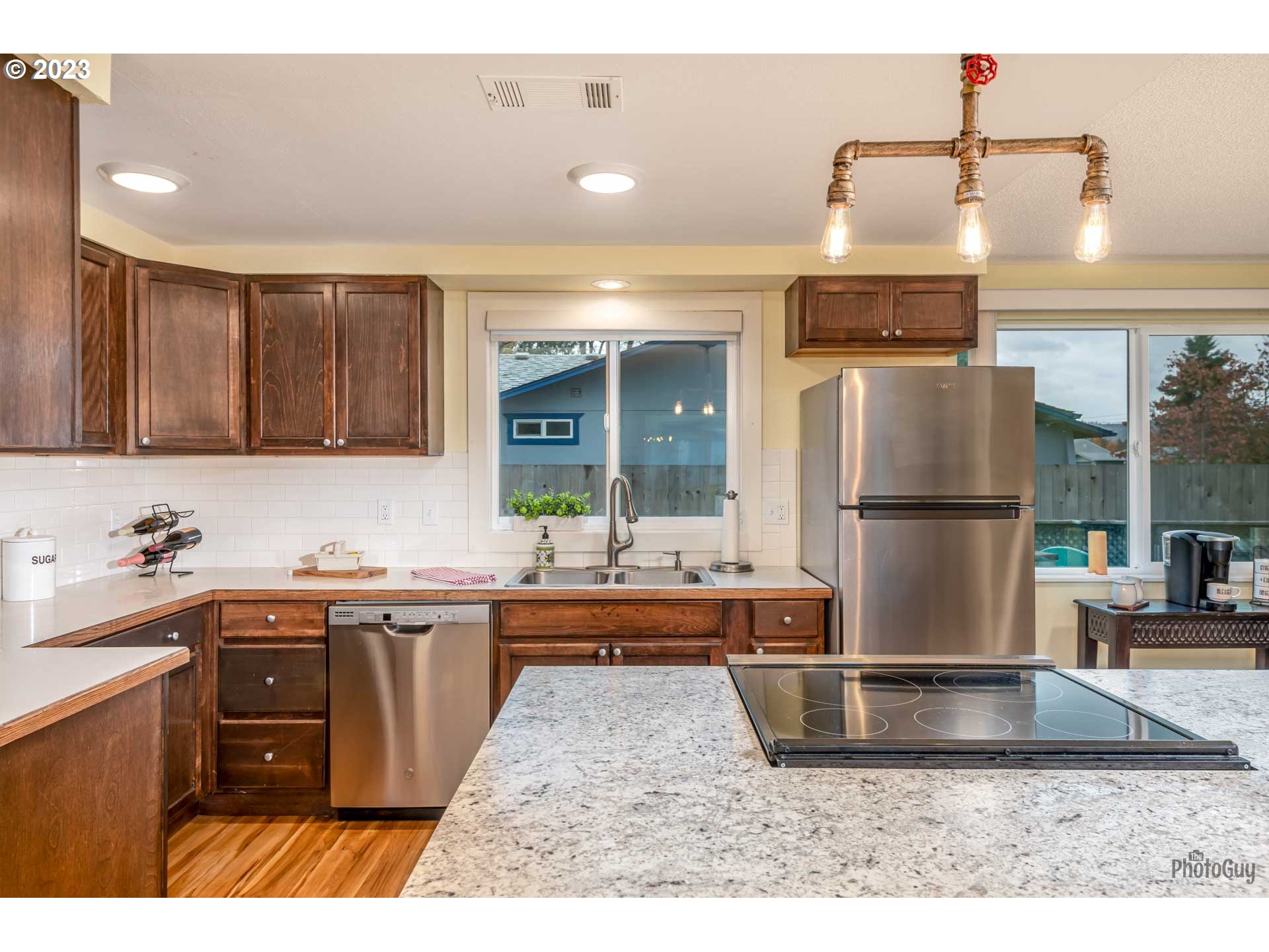 1078 56th Place Springfield, OR 97478 - Photo 9 of 31 a kitchen with kitchen island a sink and wooden cabinets