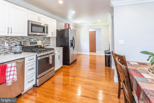 a white kitchen with stainless steel appliances and white cabinets