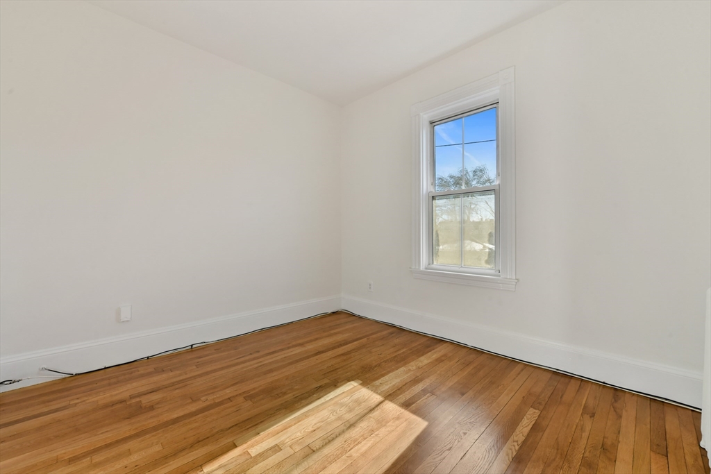 50 Mt Vernon Street, Unit 3 Boston, MA 02125 - Photo 13 of 16 a view of an empty room with wooden floor and a window