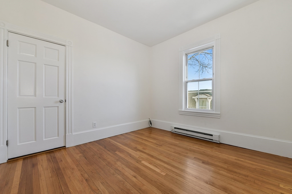 50 Mt Vernon Street, Unit 3 Boston, MA 02125 - Photo 7 of 16 an empty room with wooden floor and windows