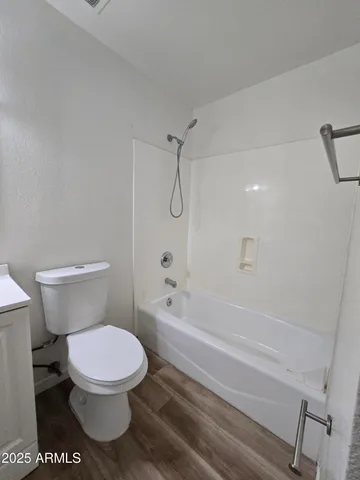 a white toilet and tub sitting next to a bathroom sink