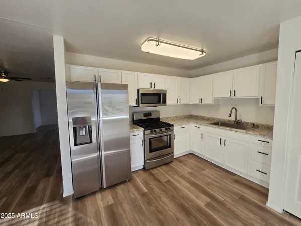 a kitchen with granite countertop a refrigerator stove and microwave