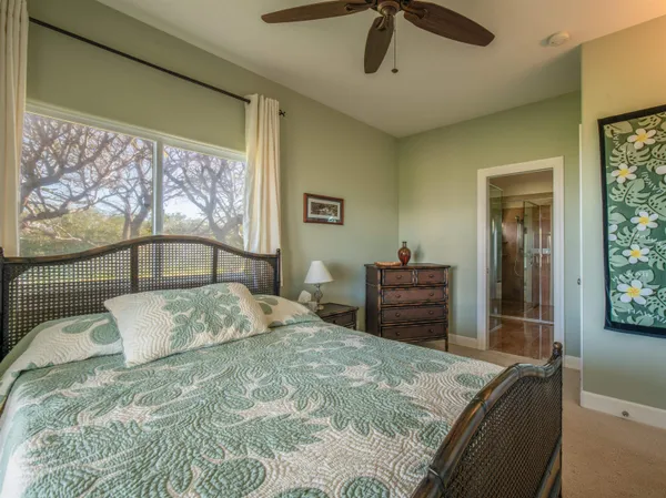 a bedroom with a bed and a dresser with mirror