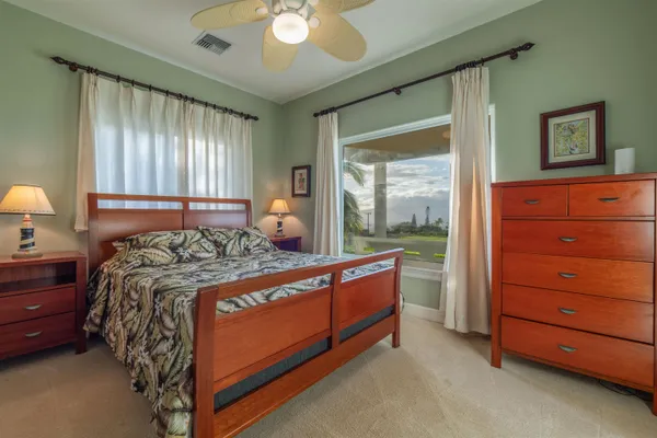 a bed sitting in a spacious bedroom next to a window