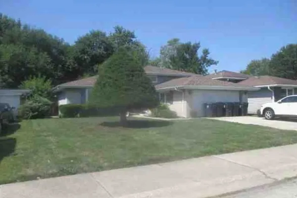 a front view of a house with a garden and yard