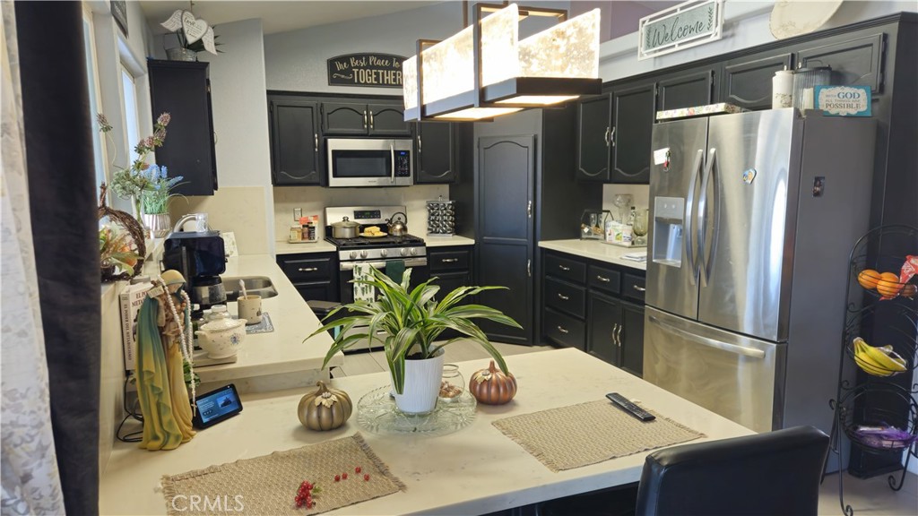 15274 Rodeo Street Hesperia, CA 92345 - Photo 19 of 43 a kitchen with stainless steel appliances a sink refrigerator and microwave