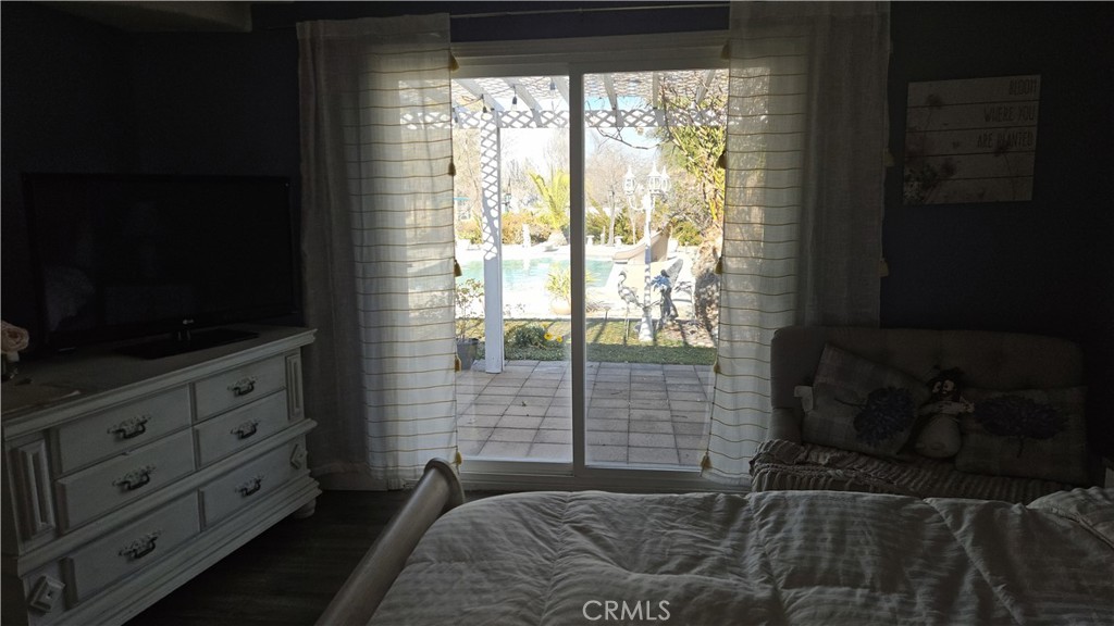 15274 Rodeo Street Hesperia, CA 92345 - Photo 39 of 43 a bedroom with a bed and a flat tv screen on dresser