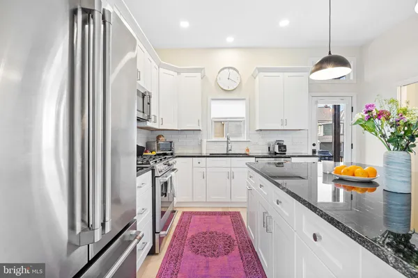 a kitchen with stainless steel appliances granite countertop a sink and a refrigerator