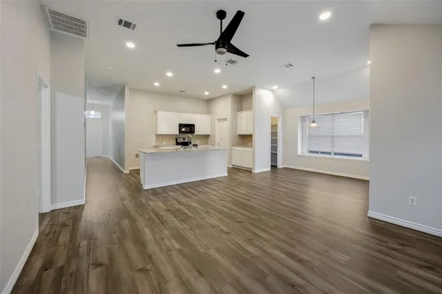 a kitchen with granite countertop a sink stove and refrigerator