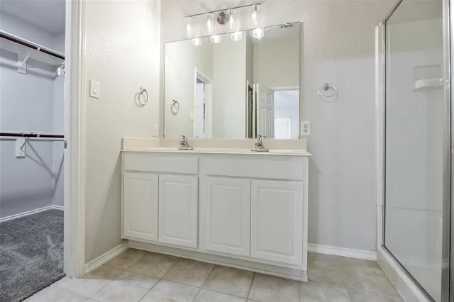 a bathroom with a shower sink vanity and mirror