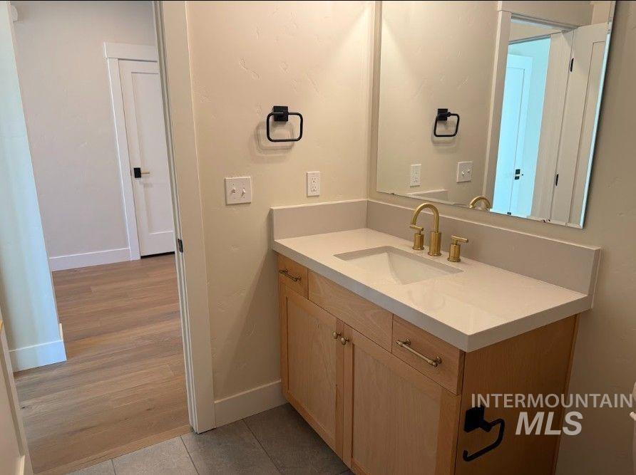 683 West Wrangler Street Meridian, ID 83646 - Photo 16 of 23 Bathroom vanity with light wood cabinetry and a light-toned countertop, featuring a rectangular undermount sink