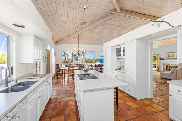 a view of a kitchen with kitchen island a large window a sink and stainless steel appliances
