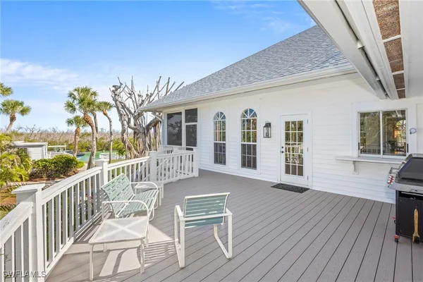 a view of a house with wooden deck and furniture