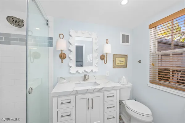 a bathroom with a toilet a sink a vanity and mirror