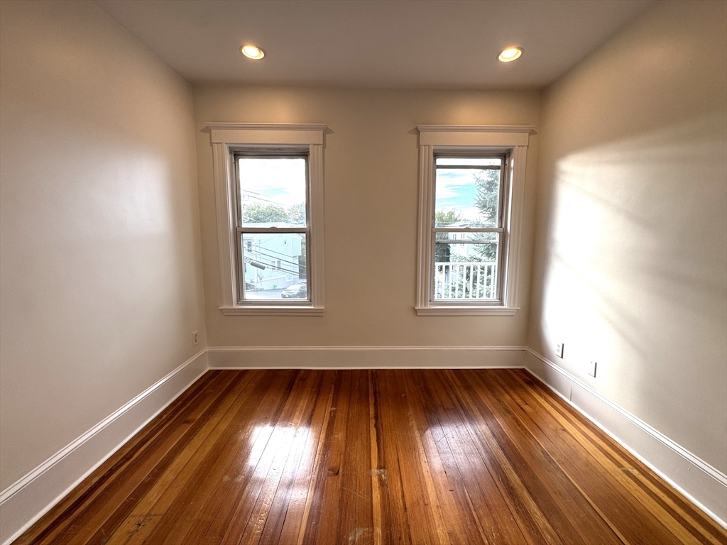 14 Breck Avenue, Unit 2 Boston, MA 02135 - Photo 14 of 26 an empty room with wooden floor and windows