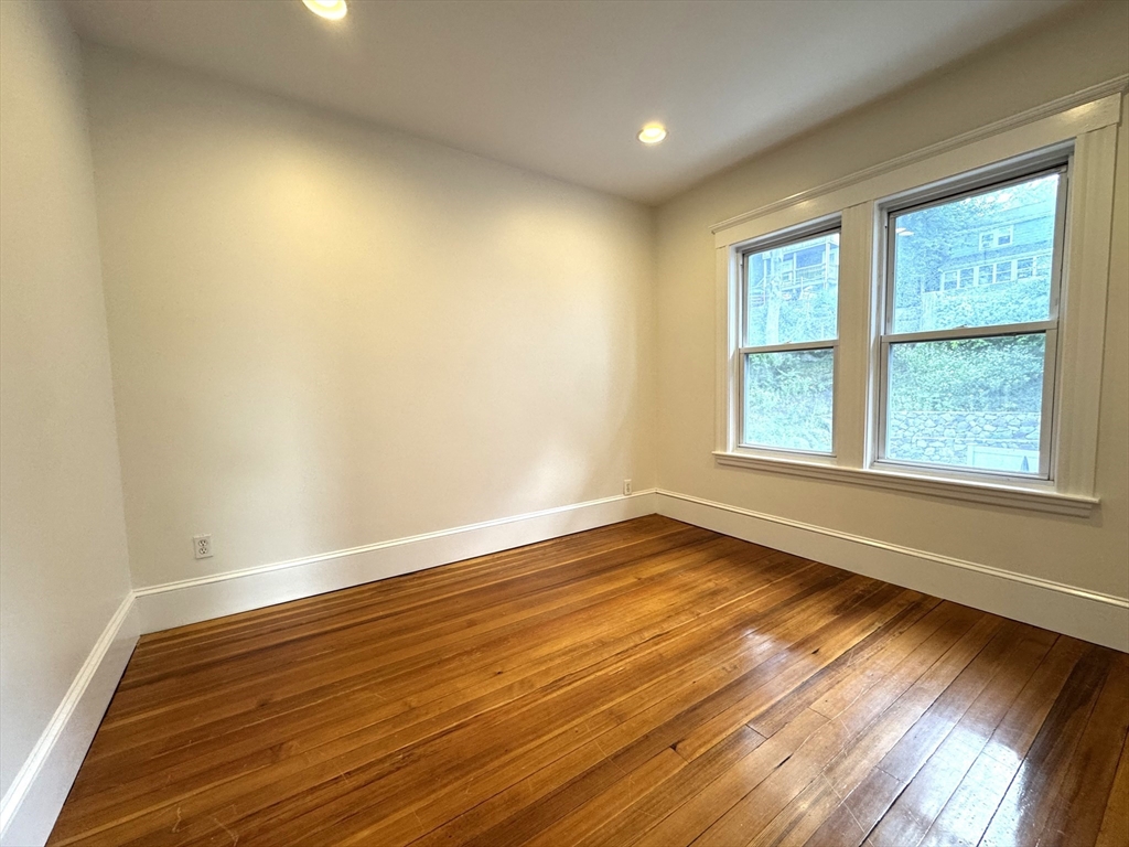 14 Breck Avenue, Unit 2 Boston, MA 02135 - Photo 15 of 26 an empty room with wooden floor and windows