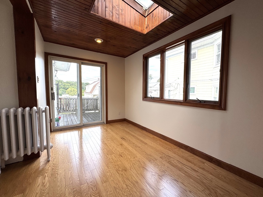 14 Breck Avenue, Unit 2 Boston, MA 02135 - Photo 16 of 26 a view of an empty room with wooden floor and a window