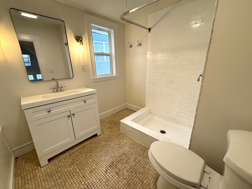 14 Breck Avenue, Unit 2 Boston, MA 02135 - Photo 21 of 26 a bathroom with a toilet a sink a mirror a vanity and shower