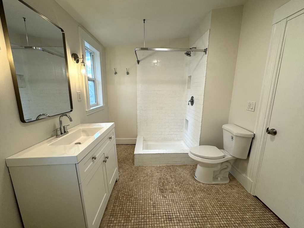 14 Breck Avenue, Unit 2 Boston, MA 02135 - Photo 23 of 26 a bathroom with a toilet sink and a mirror
