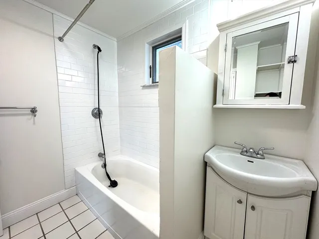 a bathroom with a bathtub a sink and a mirror