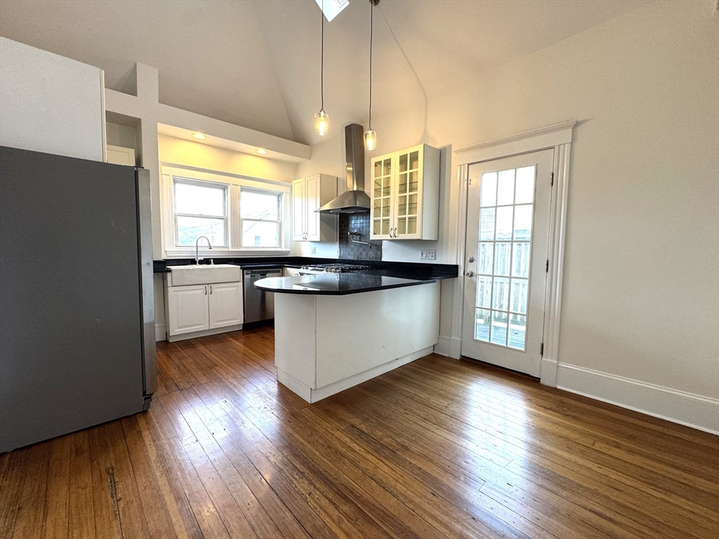 14 Breck Avenue, Unit 2 Boston, MA 02135 - Photo 3 of 26 a large kitchen with wooden floors and white walls