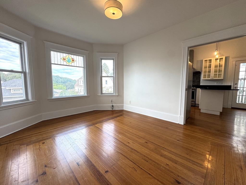 14 Breck Avenue, Unit 2 Boston, MA 02135 - Photo 4 of 26 an empty room with wooden floor and windows
