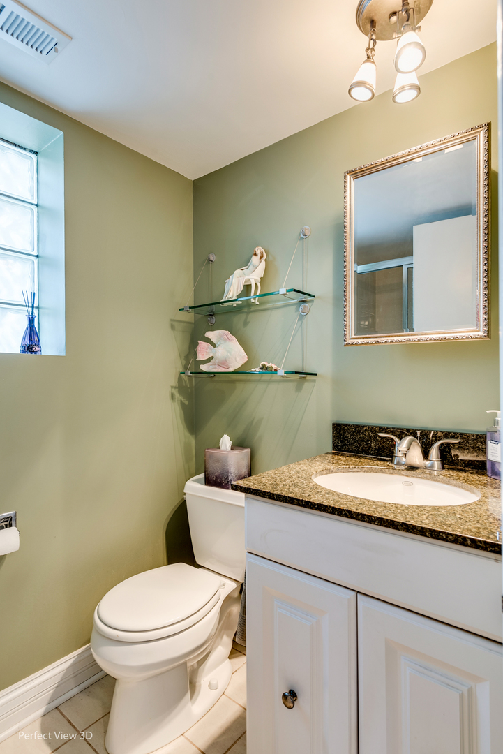 586 Siems Circle Roselle, IL 60172 - Photo 12 of 25 a bathroom with a granite countertop toilet sink and mirror
