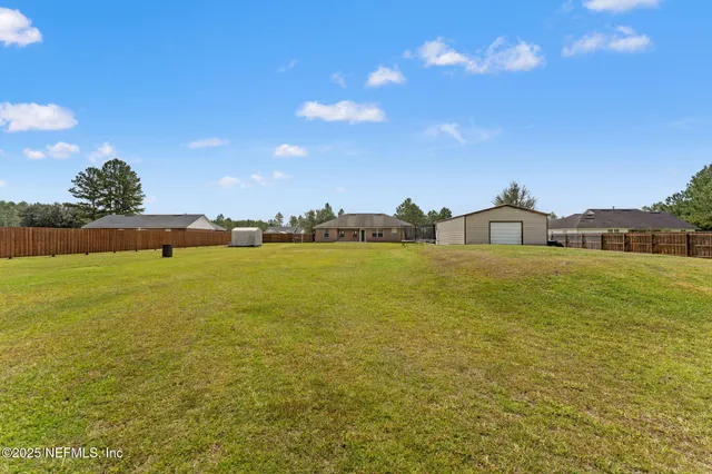 a view of a big house with a big yard and a large tree