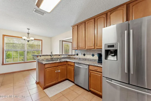 a kitchen with stainless steel appliances granite countertop a refrigerator and a sink