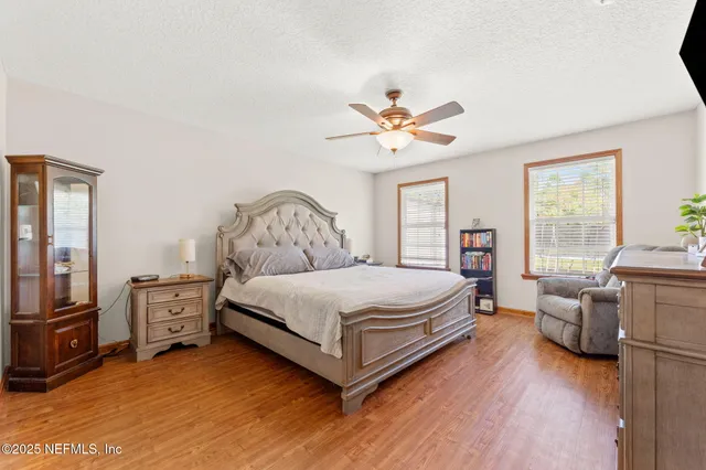 a bedroom with a bed and wooden floor